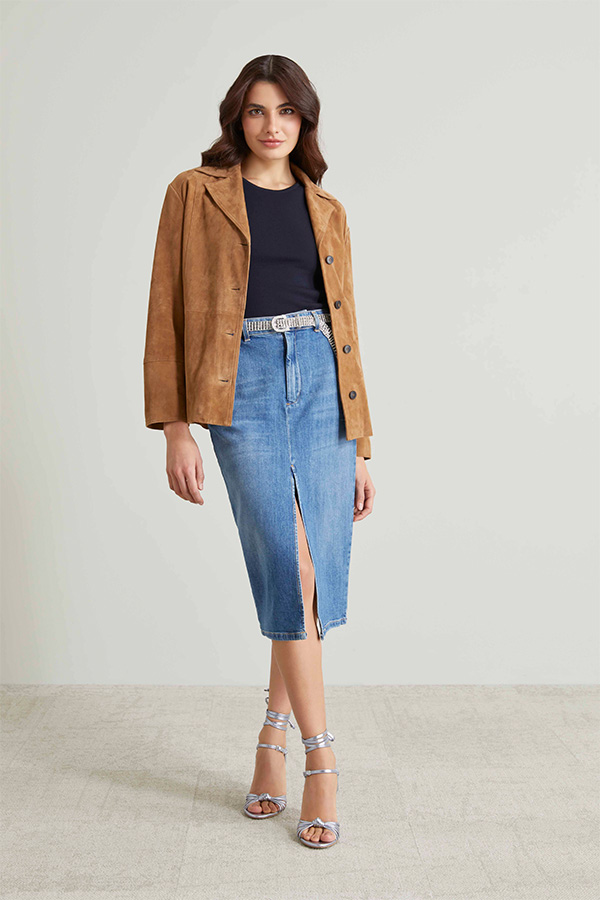 Modella indossa gonna di jeans con spacco frontale.